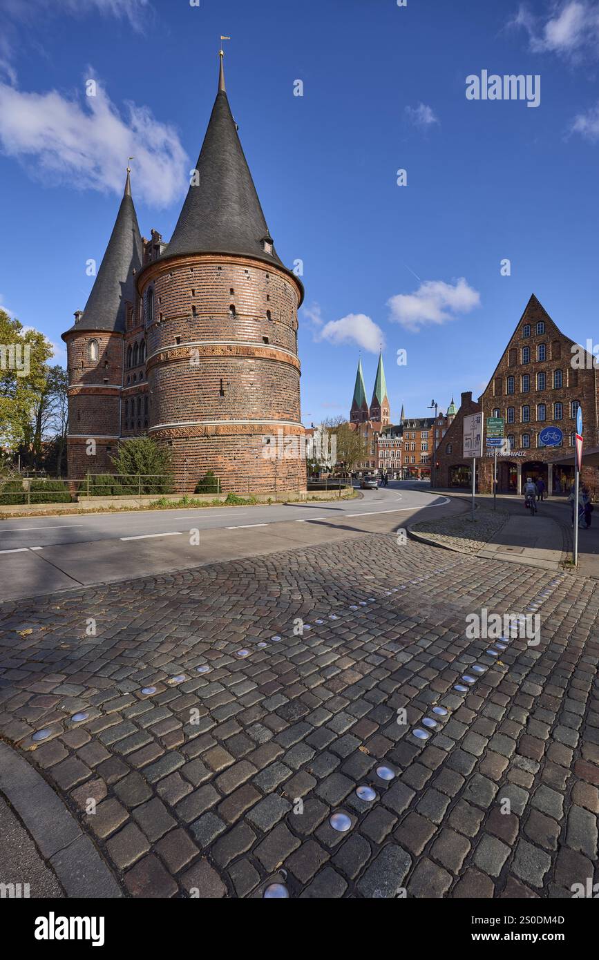 Luebeck Holstentor, side view, pedestrian crossing, cobblestone ...