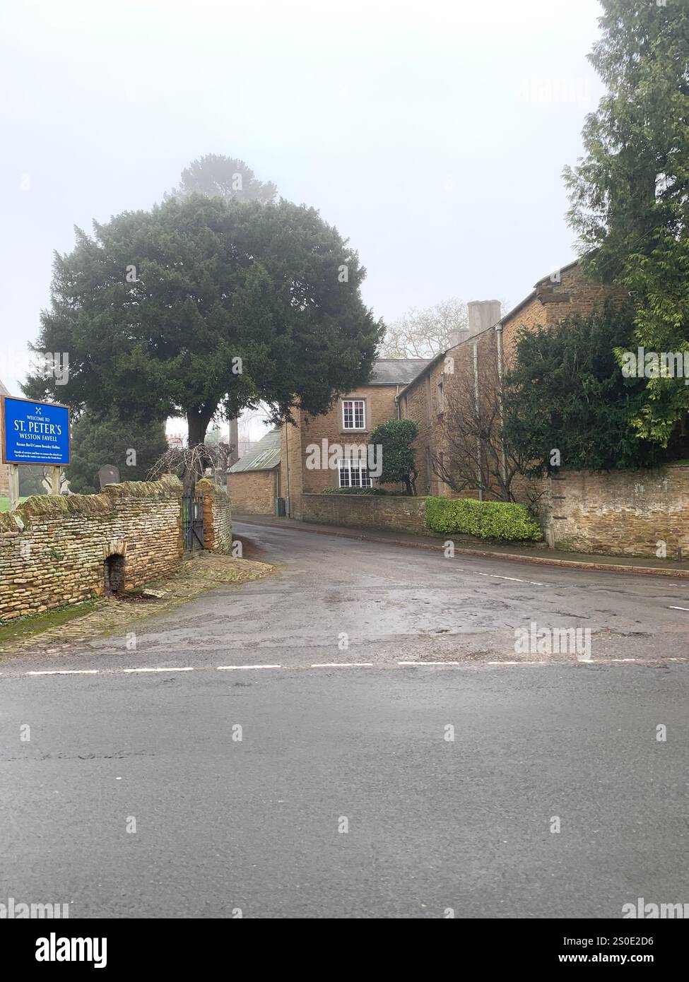 Weston Favel Village Northampton England UK place fog foggy weather thatch thatched roof Church God Christmas New Year time scaffolding trees UK - Smartphone Captured Stock Image