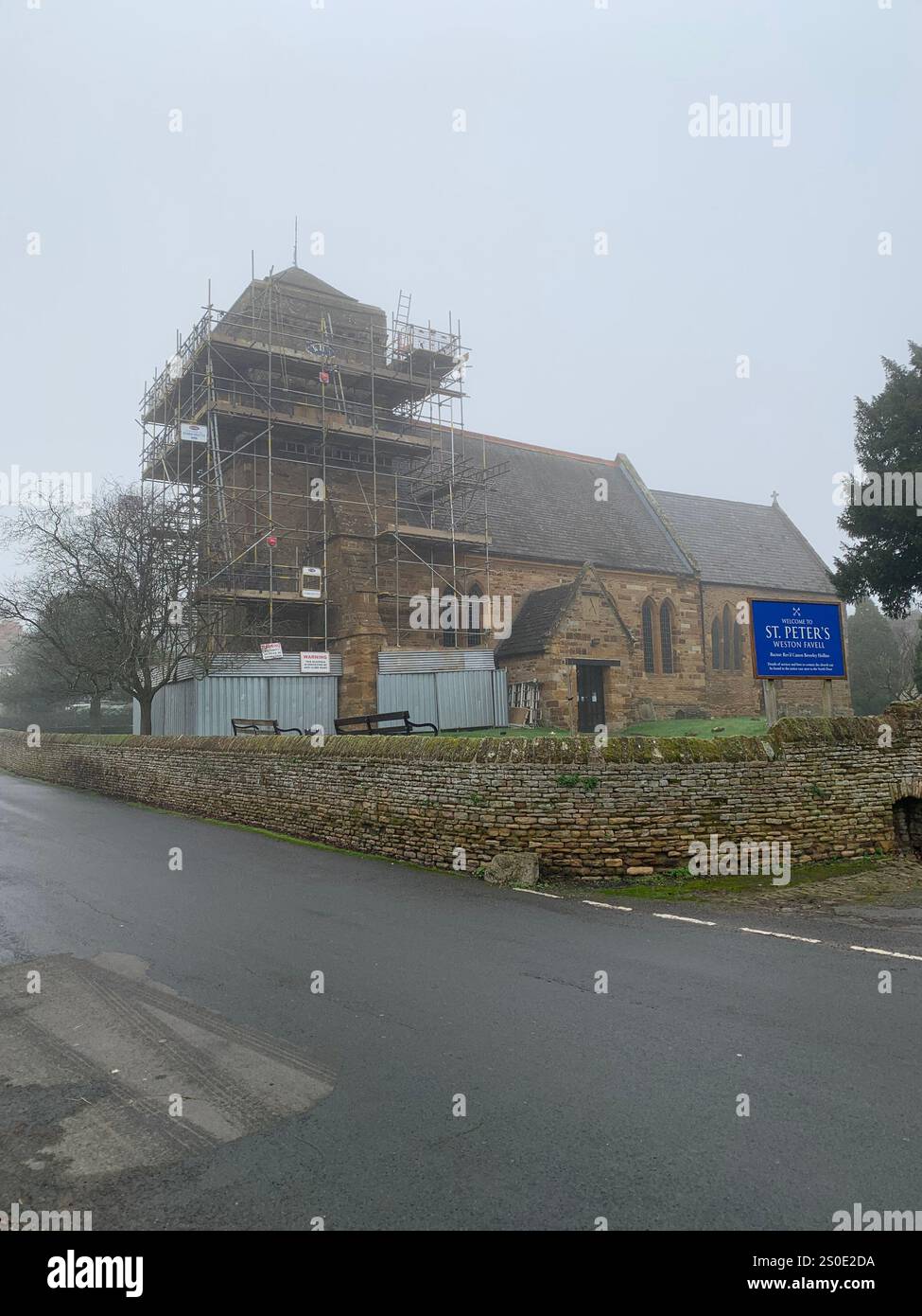 Weston Favel Village Northampton England UK place fog foggy weather thatch thatched roof Church God Christmas New Year time scaffolding trees UK - Smartphone Captured Stock Image