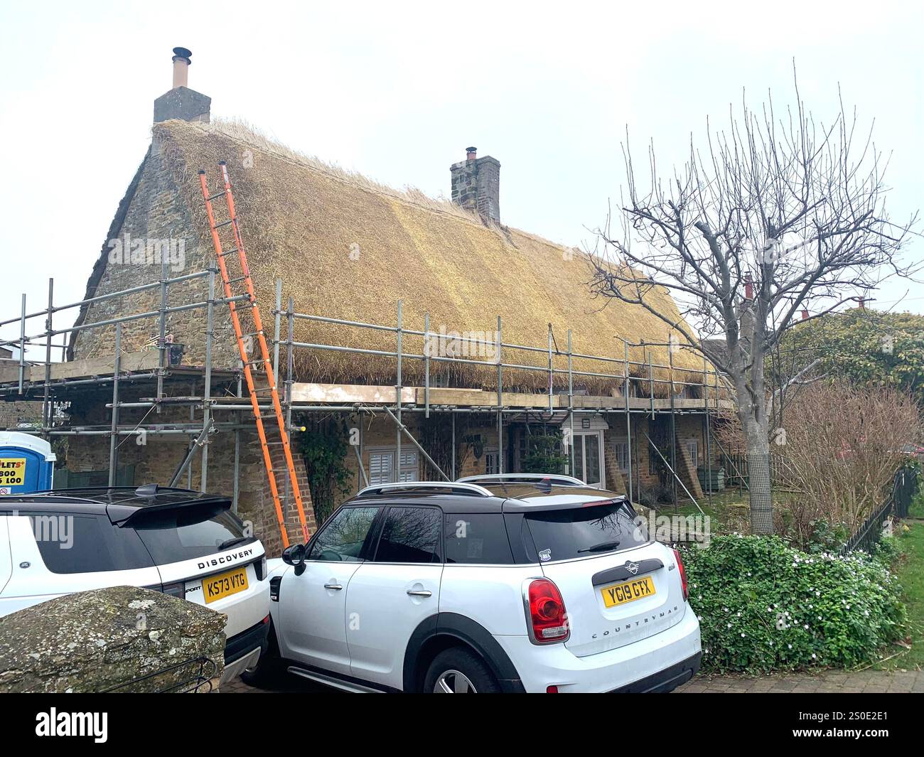 Weston Favel Village Northampton England UK place fog foggy weather thatch thatched roof Church God Christmas New Year time scaffolding trees UK - Smartphone Captured Stock Image