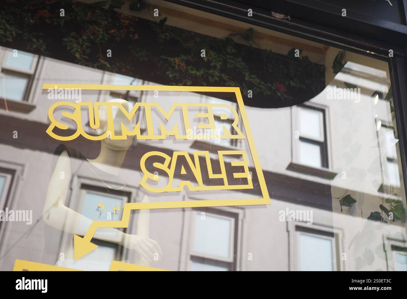 Text In Store Wall Large yellow Sale text letters on a glass wall obstruct a view inside ...