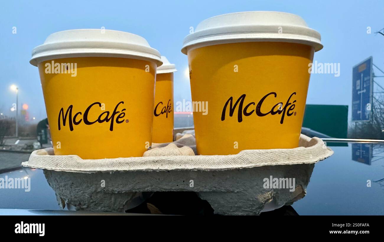 Four coffees by McCafe in paper cups for takeaway on a car roof - Smartphone Captured Stock Image