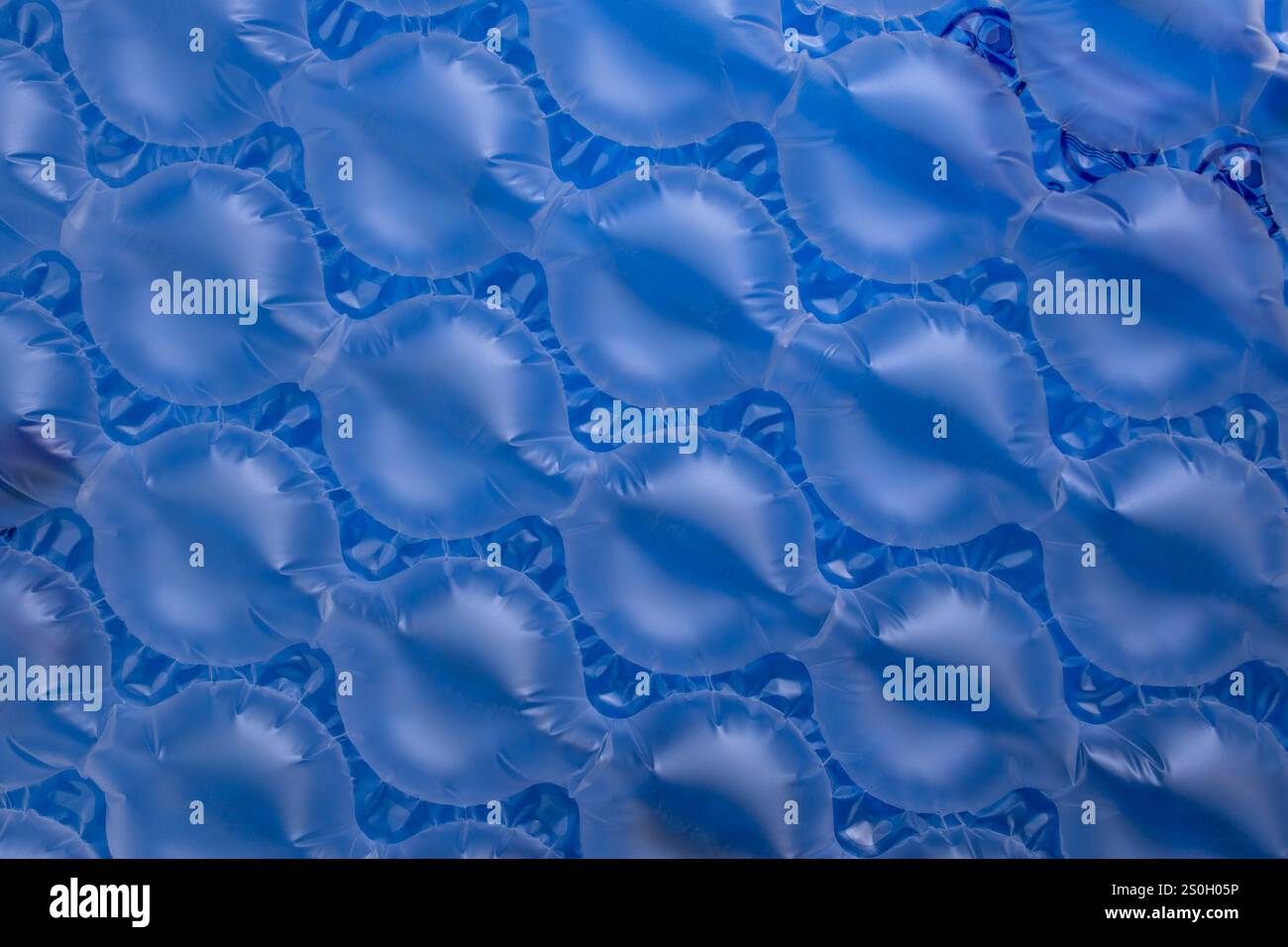 Cushions bubble wrap on blue background, abstract texture backdrop for product Stock Photo