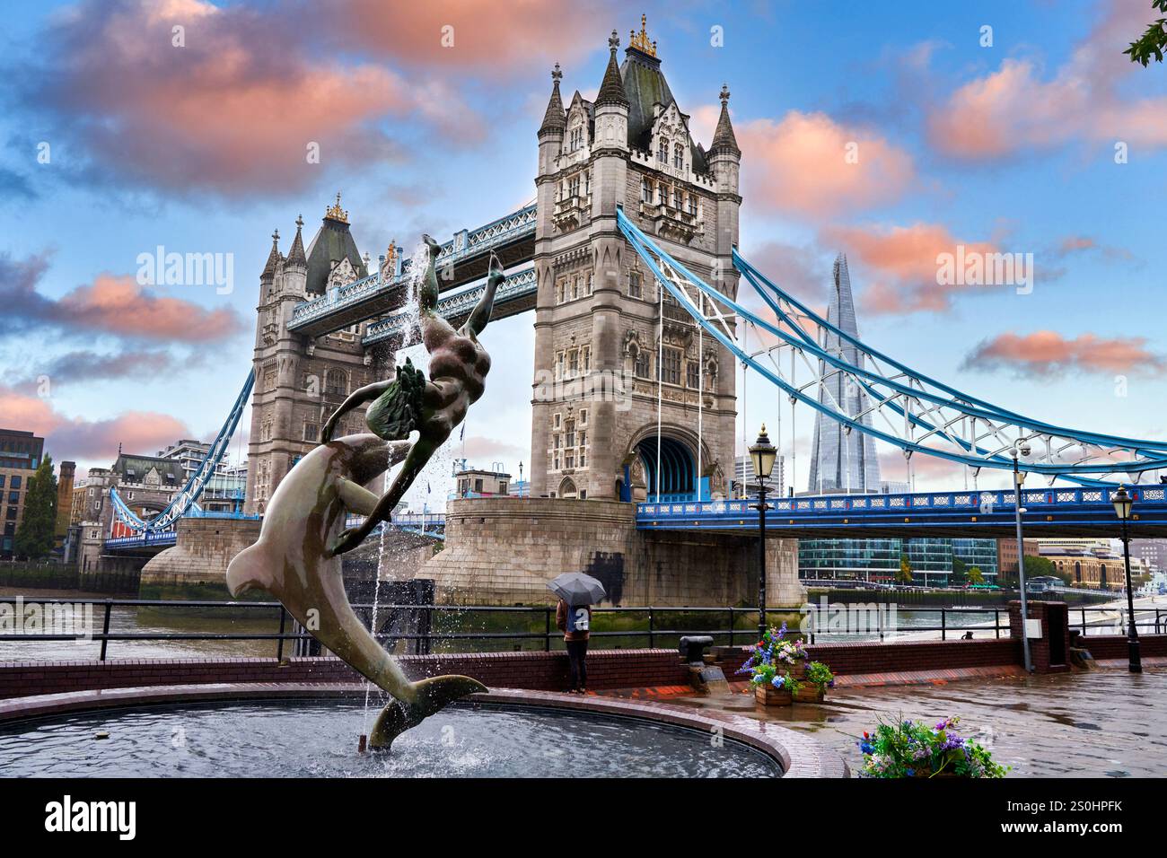 Girl with Dolphin fountain on the north bank of the Thames river, Tower Bridge, London, England, UK Stock Photo