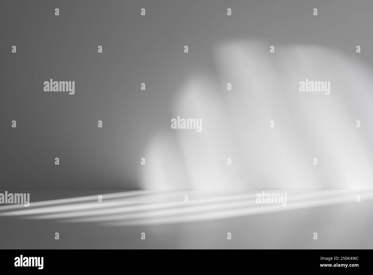 Soft abstract pattern of light and shadows on a smooth gray surface, creating a minimalist and atmospheric background. Stock Photo