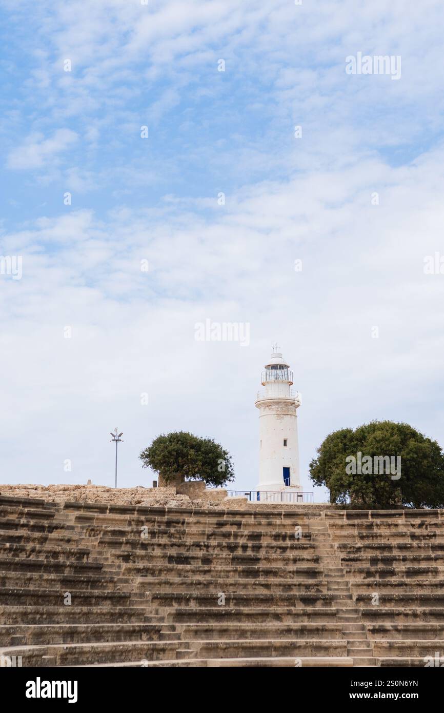 White lighthouse s under a partly cloudy sky flanked by trees Stock ...