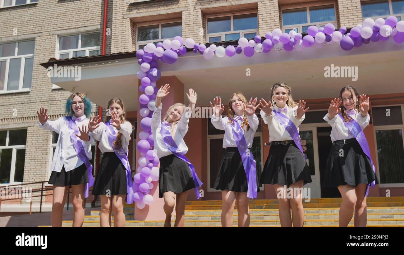 Happy graduates waving goodbye on their final day of school ...