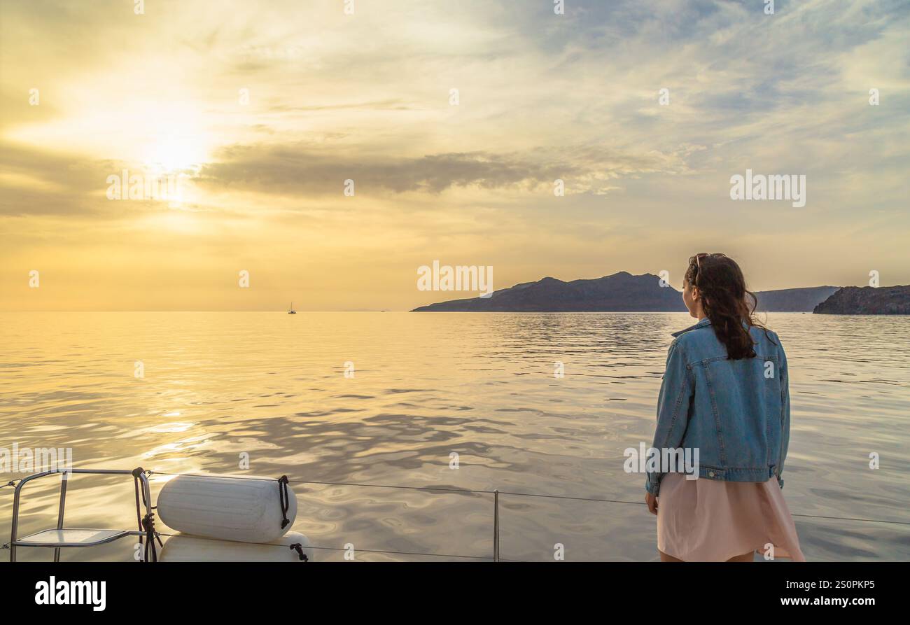 Woman Gazing at Serene Sunset Over the Calm Ocean Waters, Santorini, Greece Stock Photo