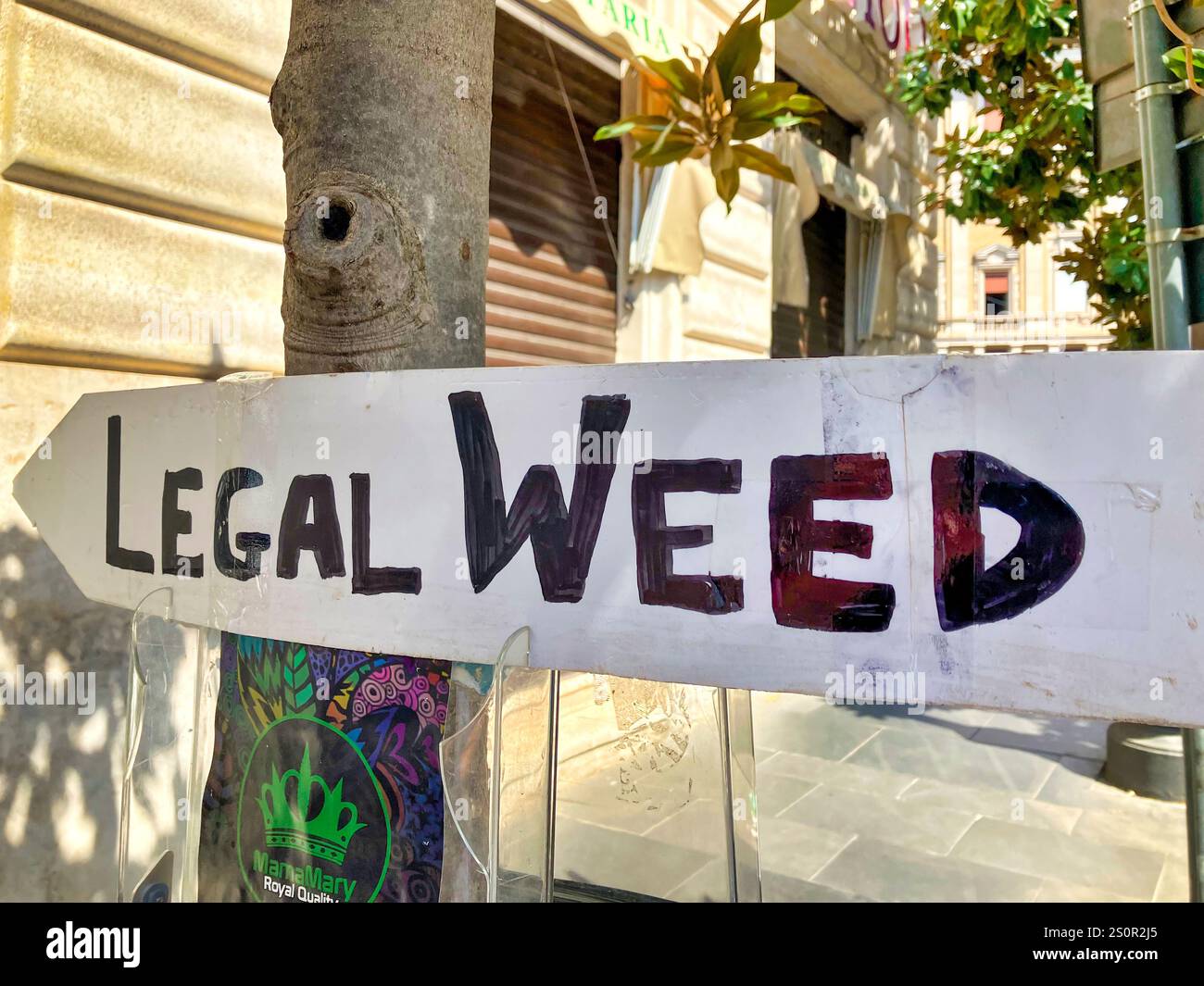 Handwritten sign pointing to a legal weed shop in Rome, Italy - Smartphone Captured Stock Image