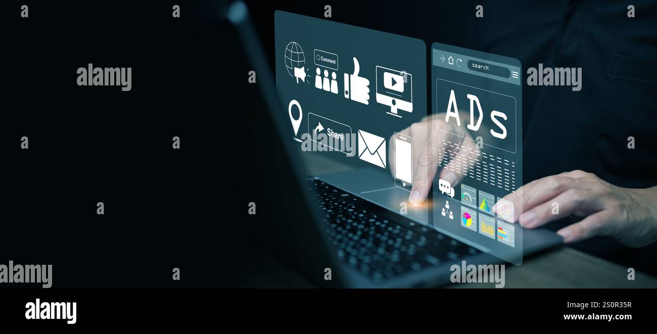 Digital marketing and advertising. A man works on online advertisement and digital ad, icons on virtual screen, using his laptop computer. Stock Photo