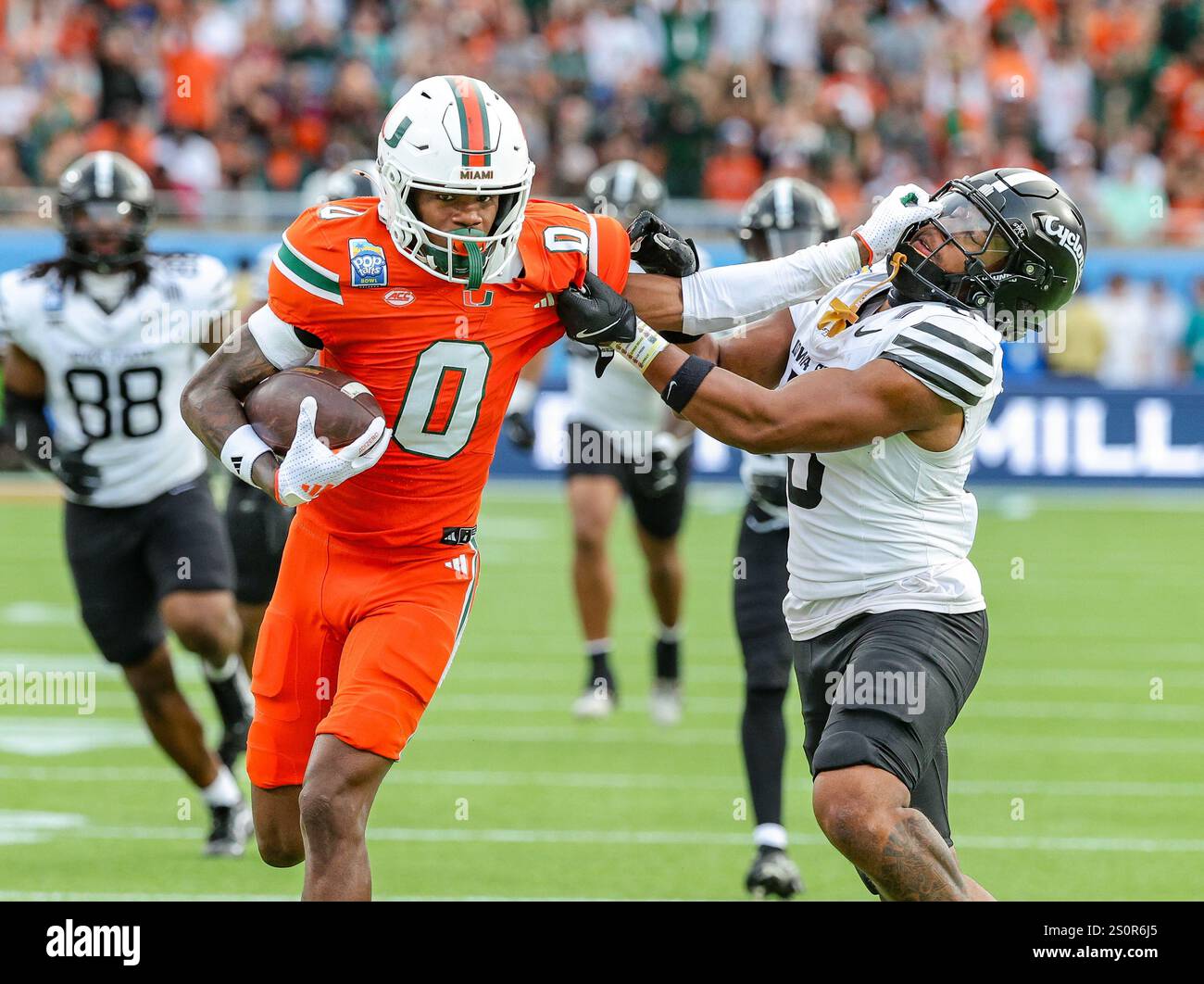 Orlando, FL, USA. 28th Dec, 2024. Miami's Joshisa Trader (0) stiff arms ...