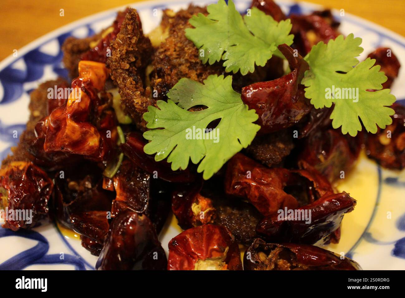 Sichuan cuisine (Chinese cuisine): fried beef and chili peppers with coriander Stock Photo