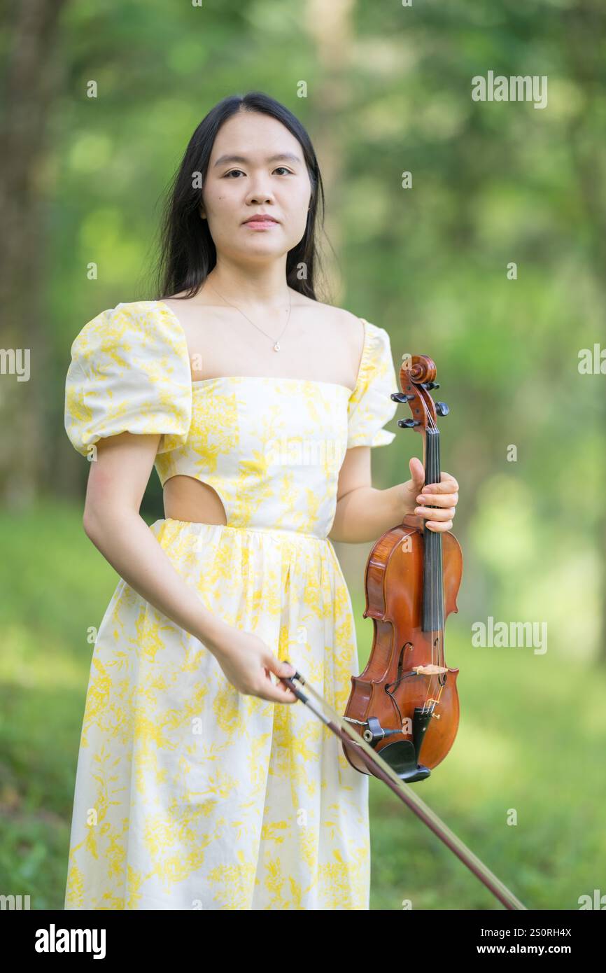 Woman playing violin in forest hi-res stock photography and images - Alamy, image size:866x1390