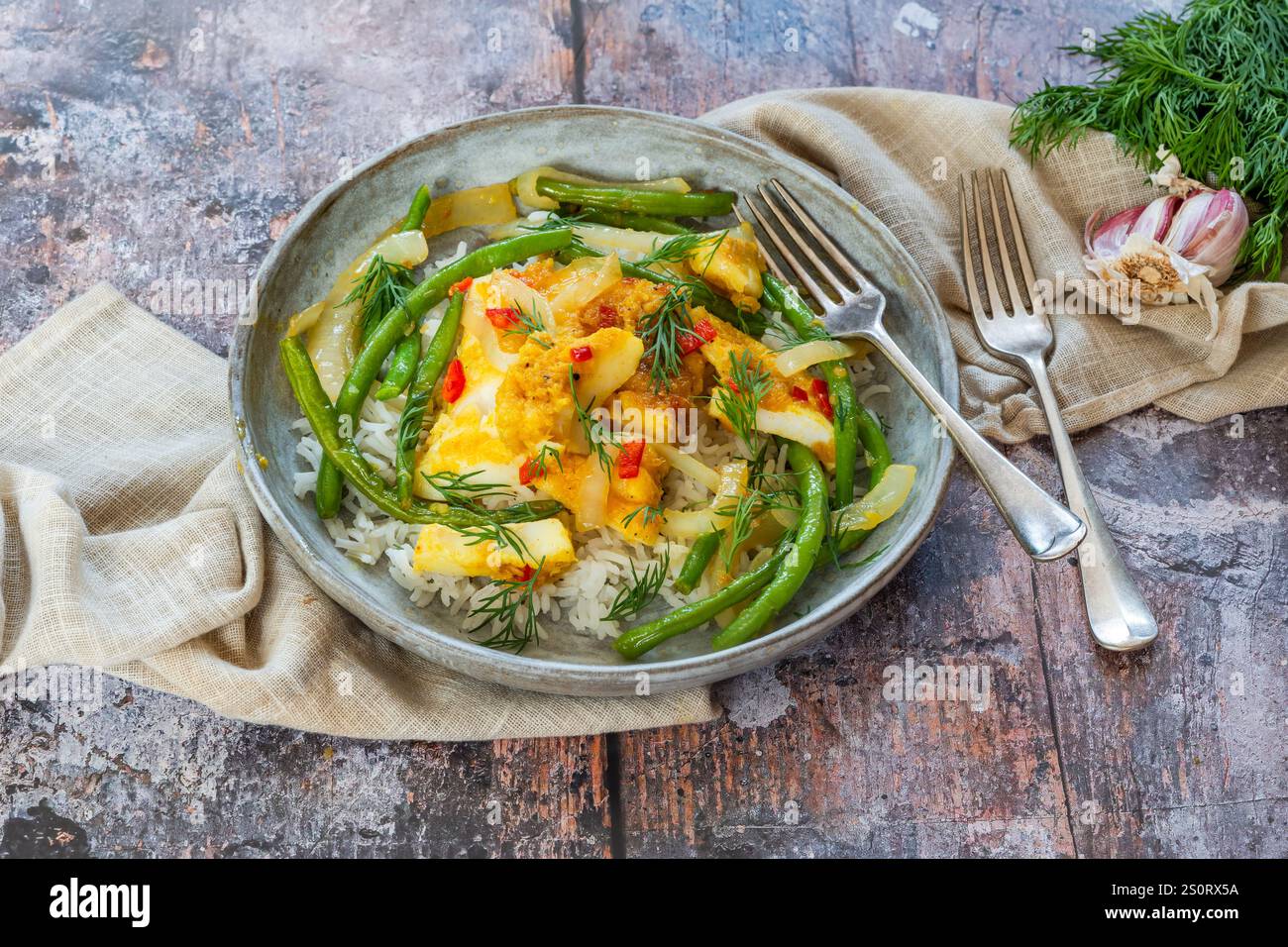 Ginger and tumerick cod with green beans and rice Stock Photo