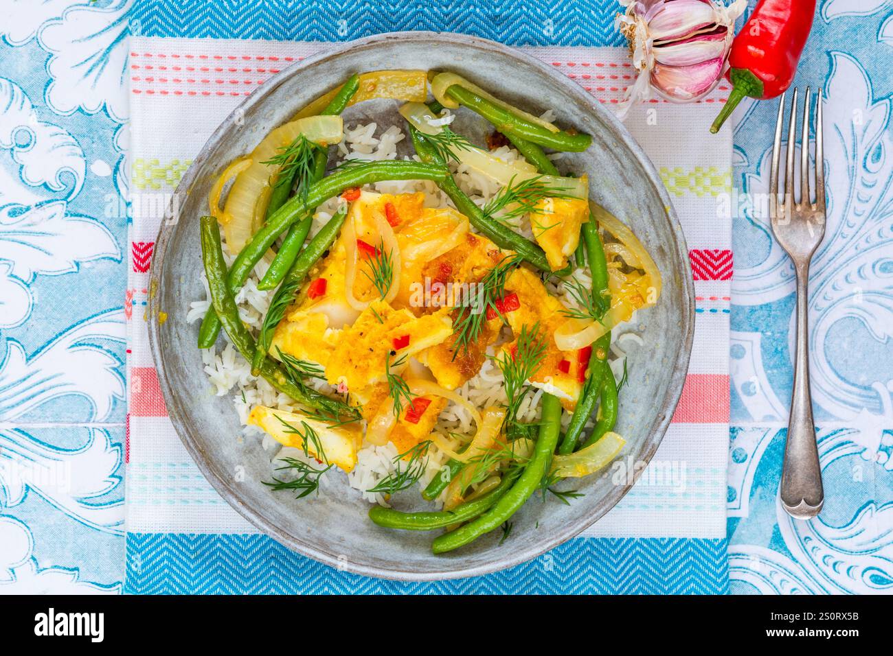 Ginger and tumerick cod with green beans and rice Stock Photo