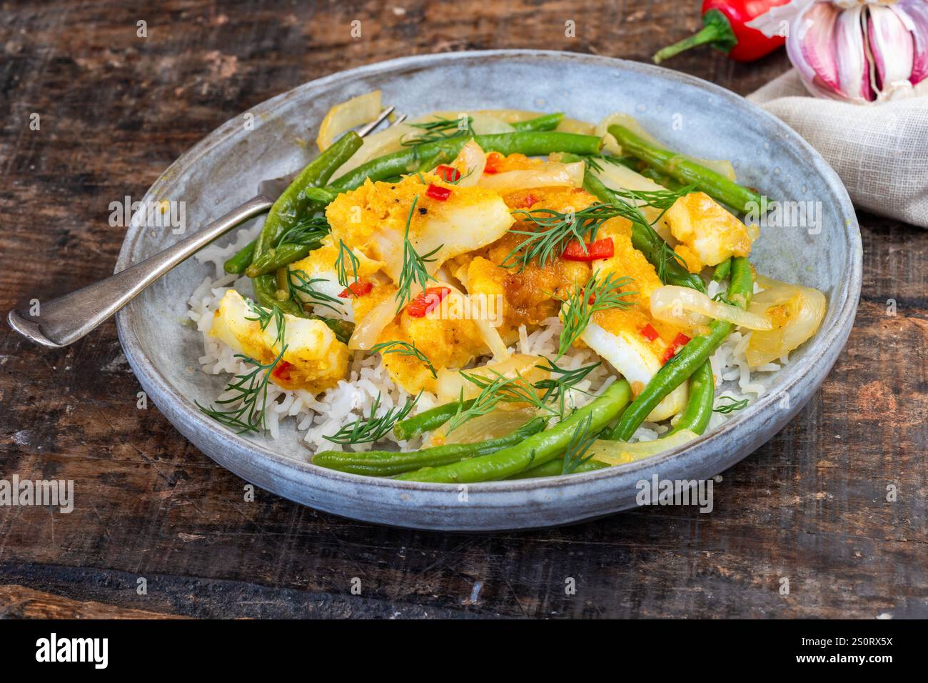 Ginger and tumerick cod with green beans and rice Stock Photo