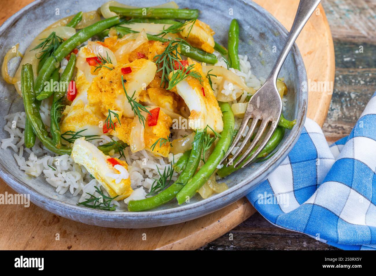 Ginger and tumerick cod with green beans and rice Stock Photo