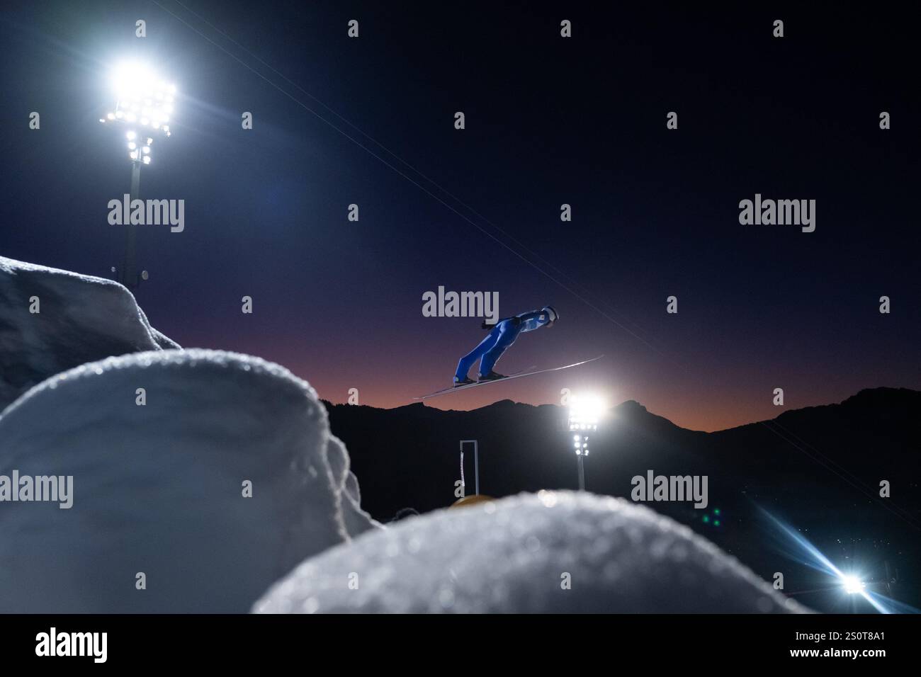 Symbolbild / Themenfoto Skispringer im Sonnenuntergang unter Flutlicht