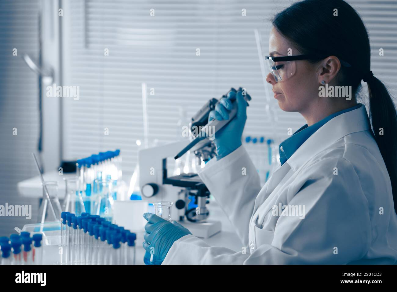 A Research Scientist is meticulously analyzing various samples in a cuttingedge, hightech laboratory equipped with the latest technology to advance Stock Photo