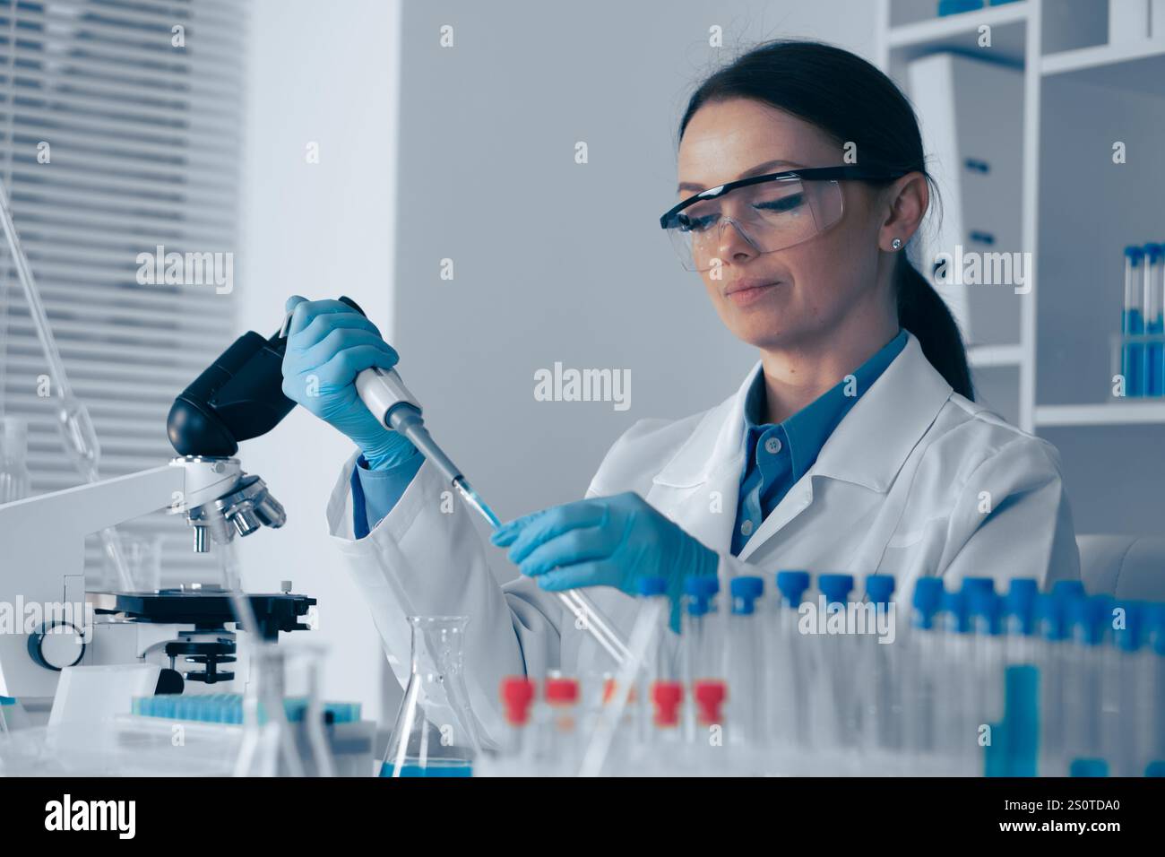 A skilled Research Scientist conducts complex experiments in a modern ...