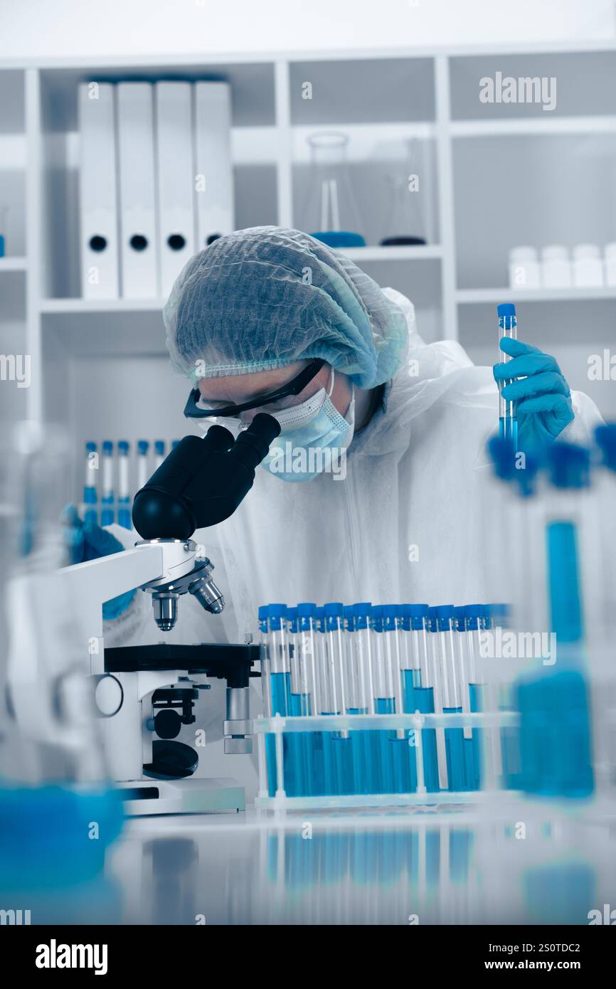 In a thoroughly modern laboratory setting, a dedicated scientist is carefully analyzing various samples under a highquality microscope, performing Stock Photo