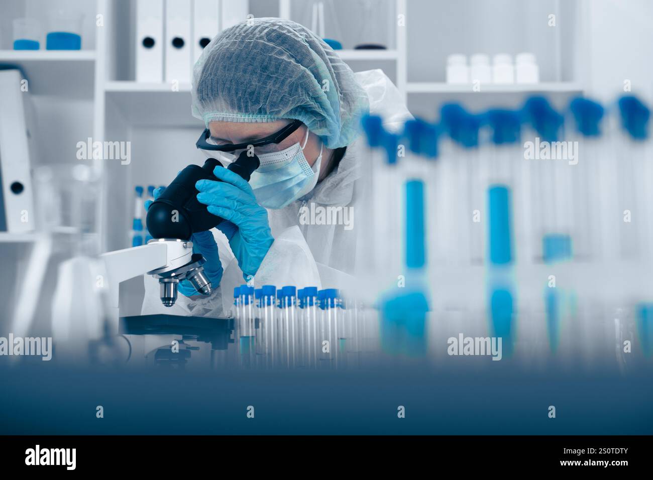 Scientist Analyzing Samples Under Microscope in Modern Laboratory Environment Stock Photo