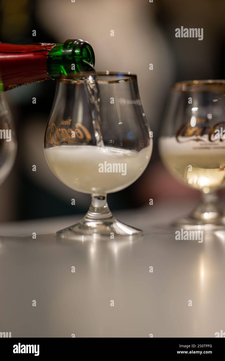 , Deutschland, 28.12.2024,  Eine Sektflasche gießt perlenden Sekt in ein elegantes Glas mit goldener Verzierung. Ein Moment von Genuss und Feierlichke Stock Photo