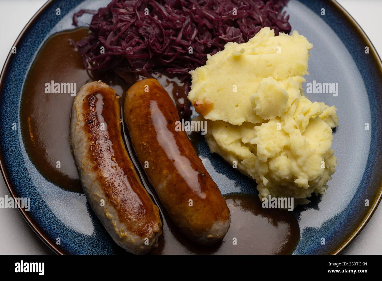 , Deutschland, 29.12.2024, Bratwürste mit dunkler Soße, Rotkohl und ...