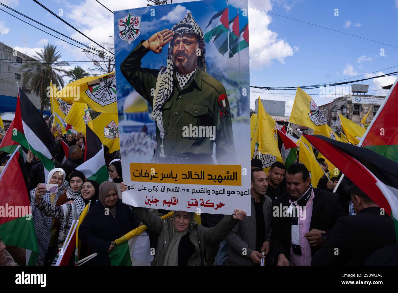 A woman holds a poster of the late Palestinian leader Yasser Arafat ...