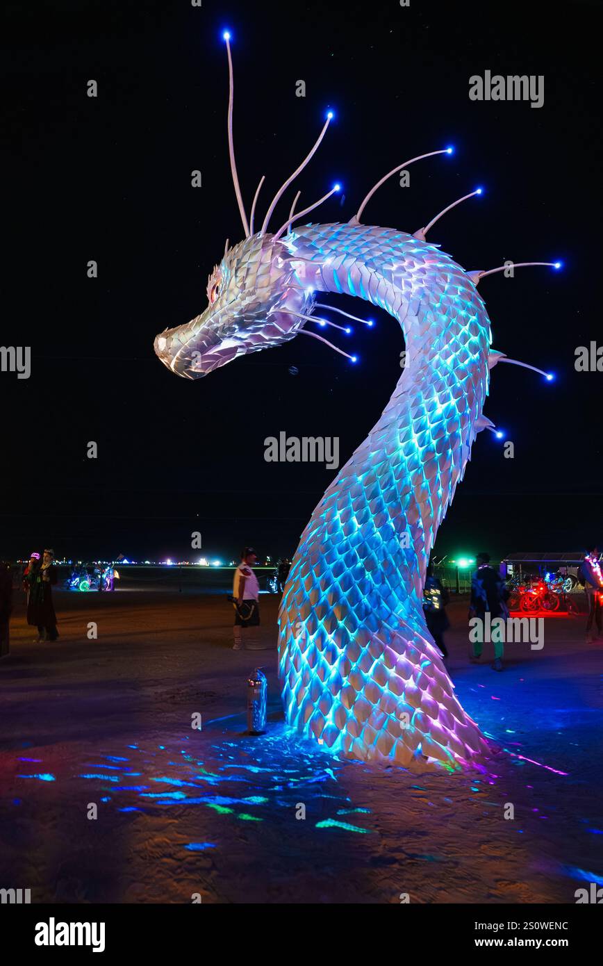 Illuminated Serpent Art Installation at Desert Festival Night Stock Photo