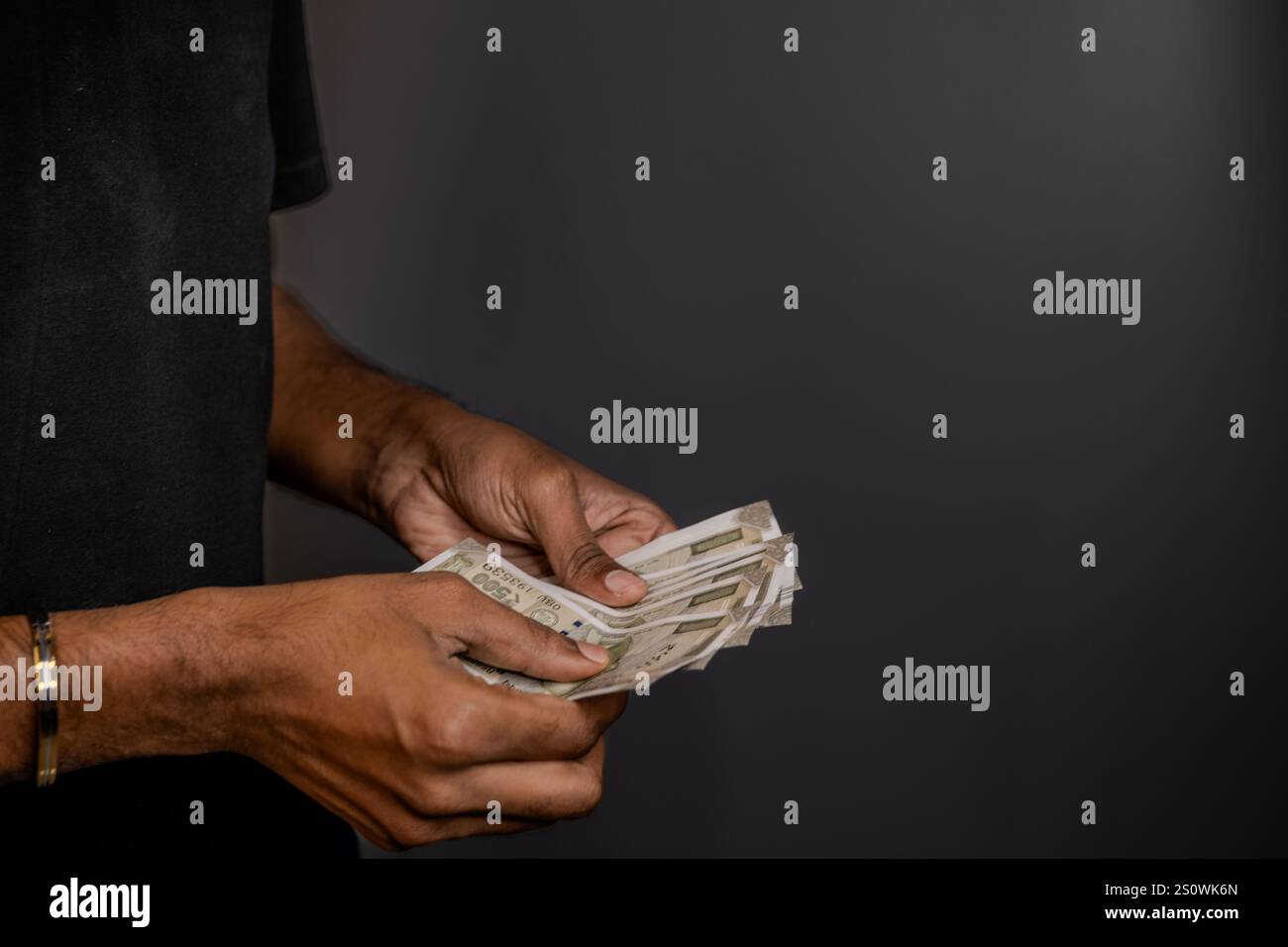 Hands counting Indian Rupees against a dark background. Concepts of ...