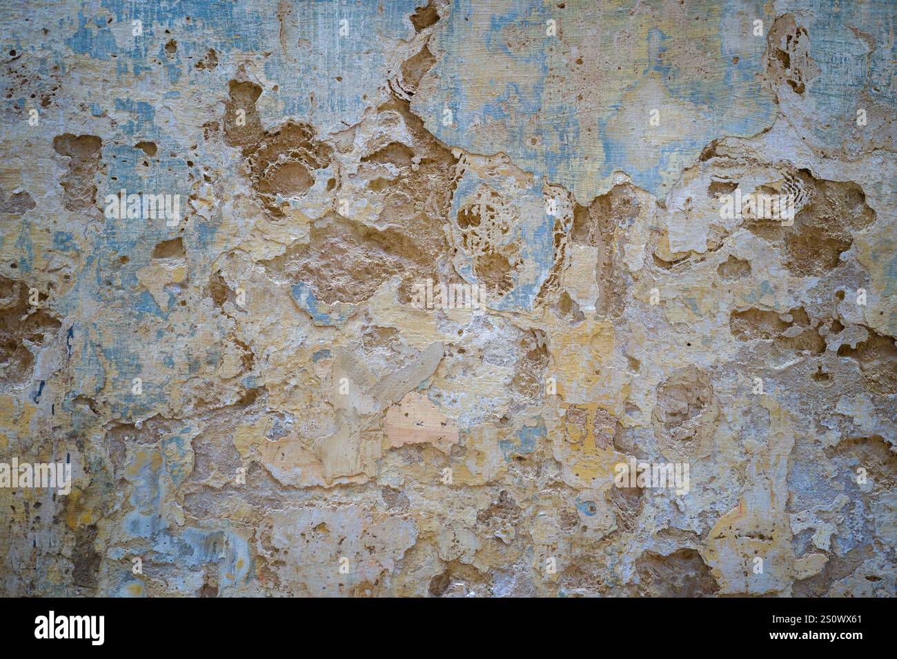 Faded and peeling paintwork on rendered wall of old building in Mdina, Malta Stock Photo