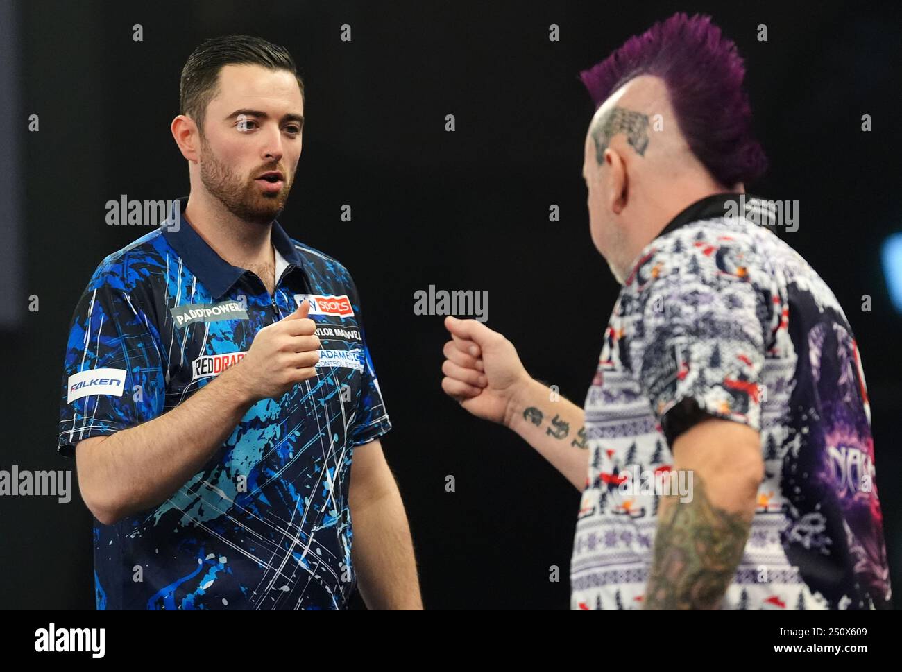 Luke Humphries walks out to play Peter Wright (right) on day twelve of