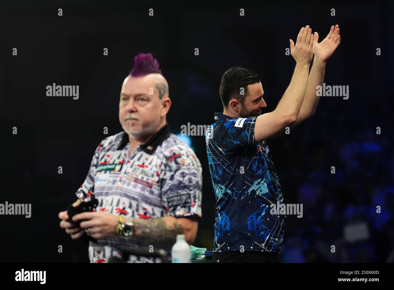 Luke Humphries walks out to play Peter Wright (left) on day twelve of
