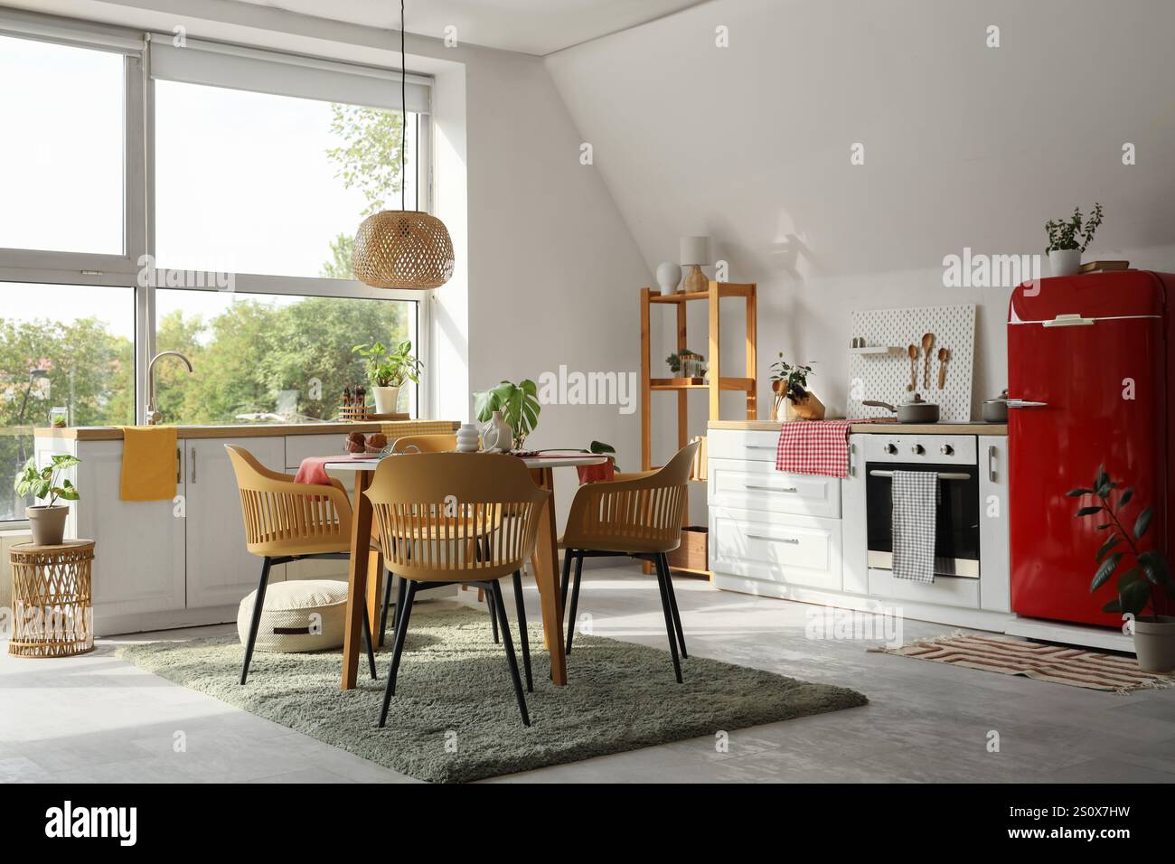 Interior of light kitchen with counters, dining table and shelf unit ...