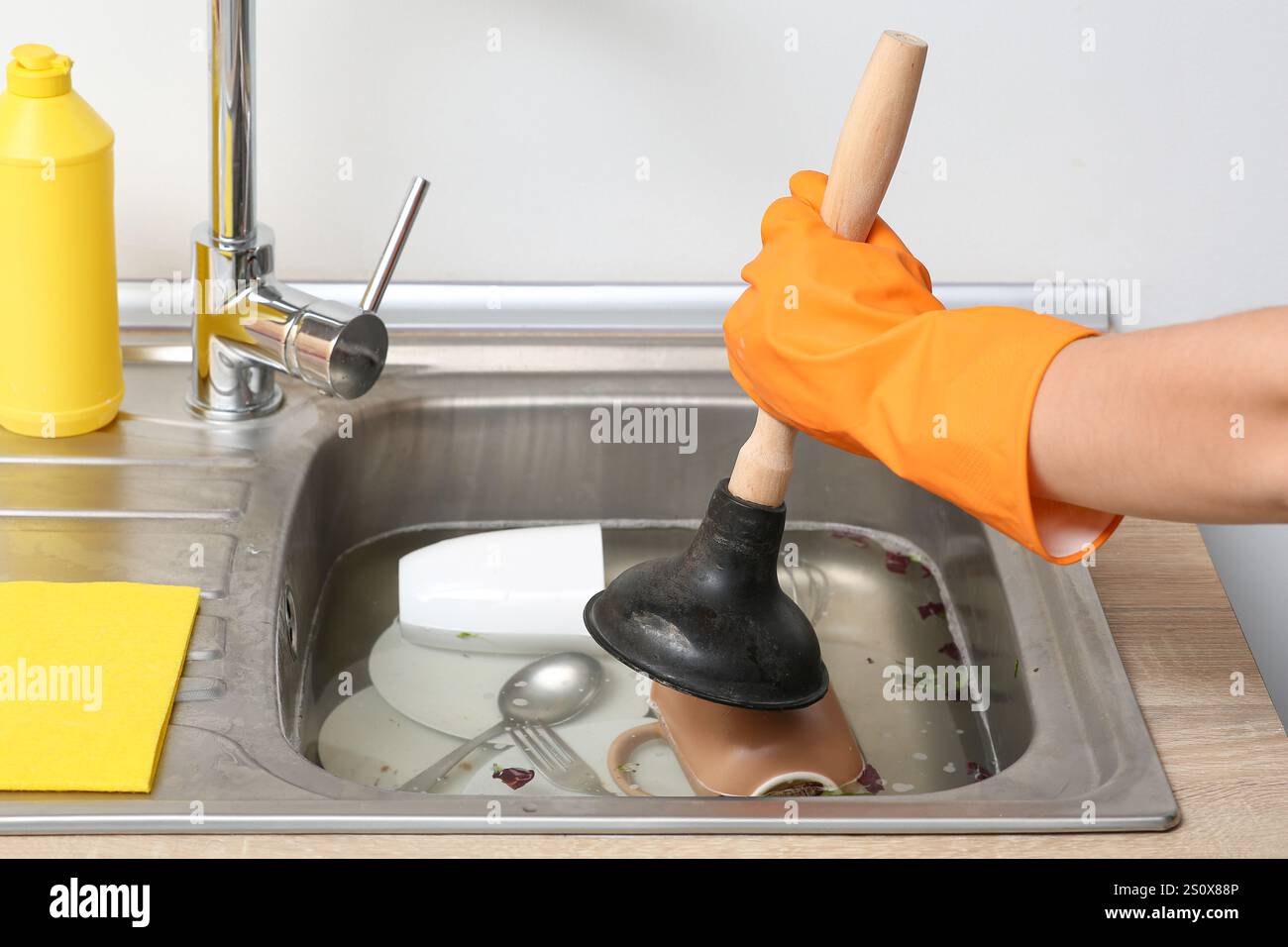 Woman cleaning clogged kitchen sink with plunger, closeup Stock Photo ...