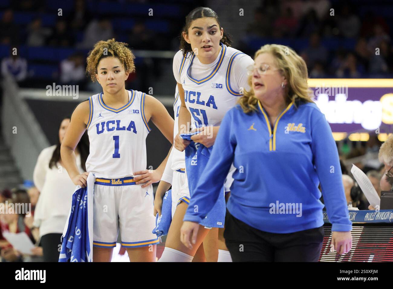 UCLA guard Kiki Rice, left, and center Lauren Betts, center, speak with