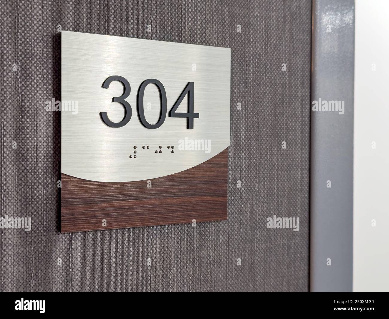 Photos of a brown and silver hotel room number 304 with braille Stock