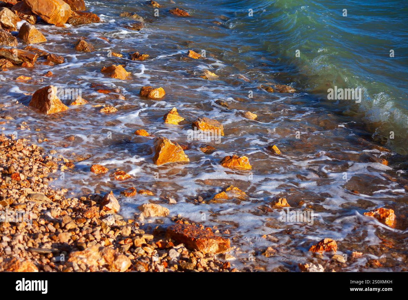 Rocky shoreline waves gently washing hi-res stock photography and ...