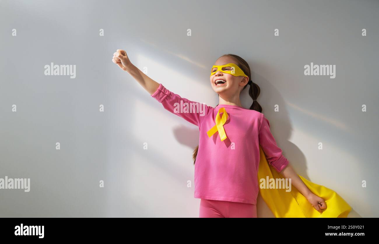 World Childhood cancer Day. Girl in superhero costume with golden