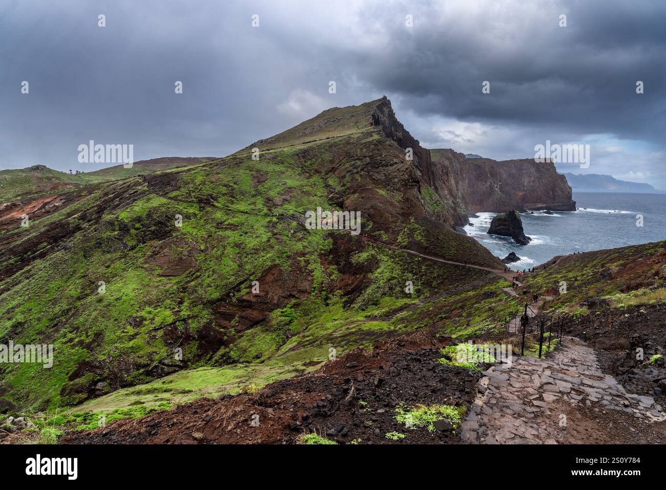 Scenic view of green cliffs leading to the ocean under moody storm ...