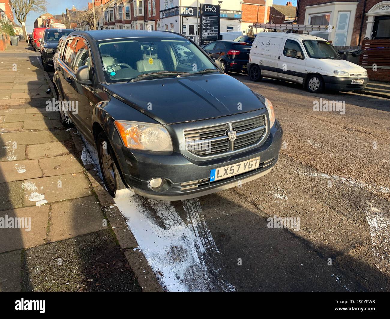 paint in street in gutter wet white mess street car damage damaged Northampton town trod trodden footprints outside cars left Christmas walk walking - Smartphone Captured Stock Image