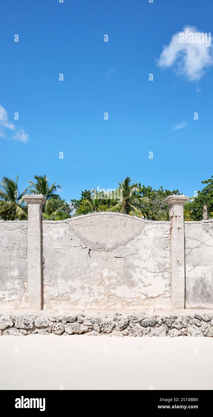 Old cracked concrete fence by a beach. Stock Photo