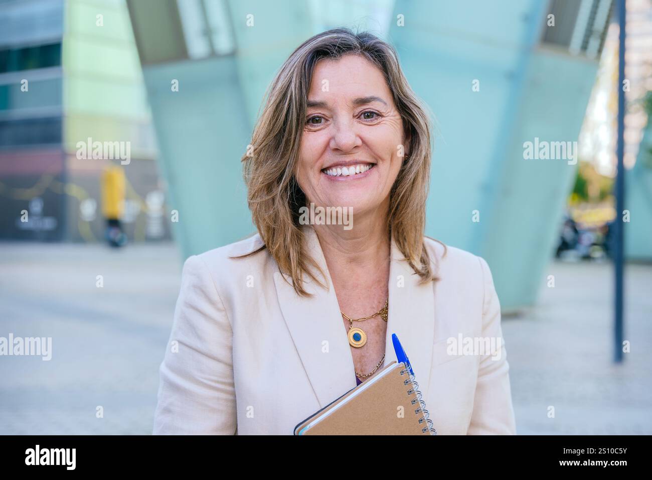 Smiling Businesswoman Holding Notebook Outdoors Stock Photo