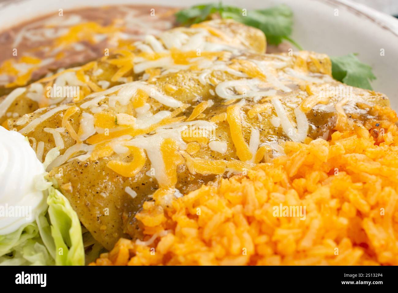 A view of a plate of enchiladas with green sauce. Stock Photo