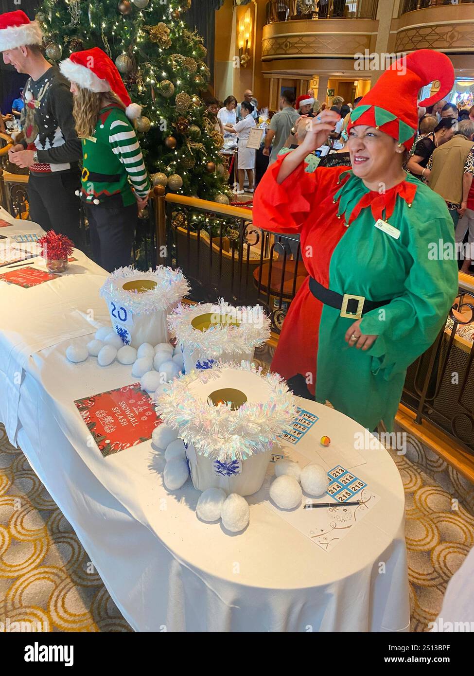 Christmas on Cunard Queen Elizabeth, staff member dressed as an elf for Snowball splash game - Smartphone Captured Stock Image