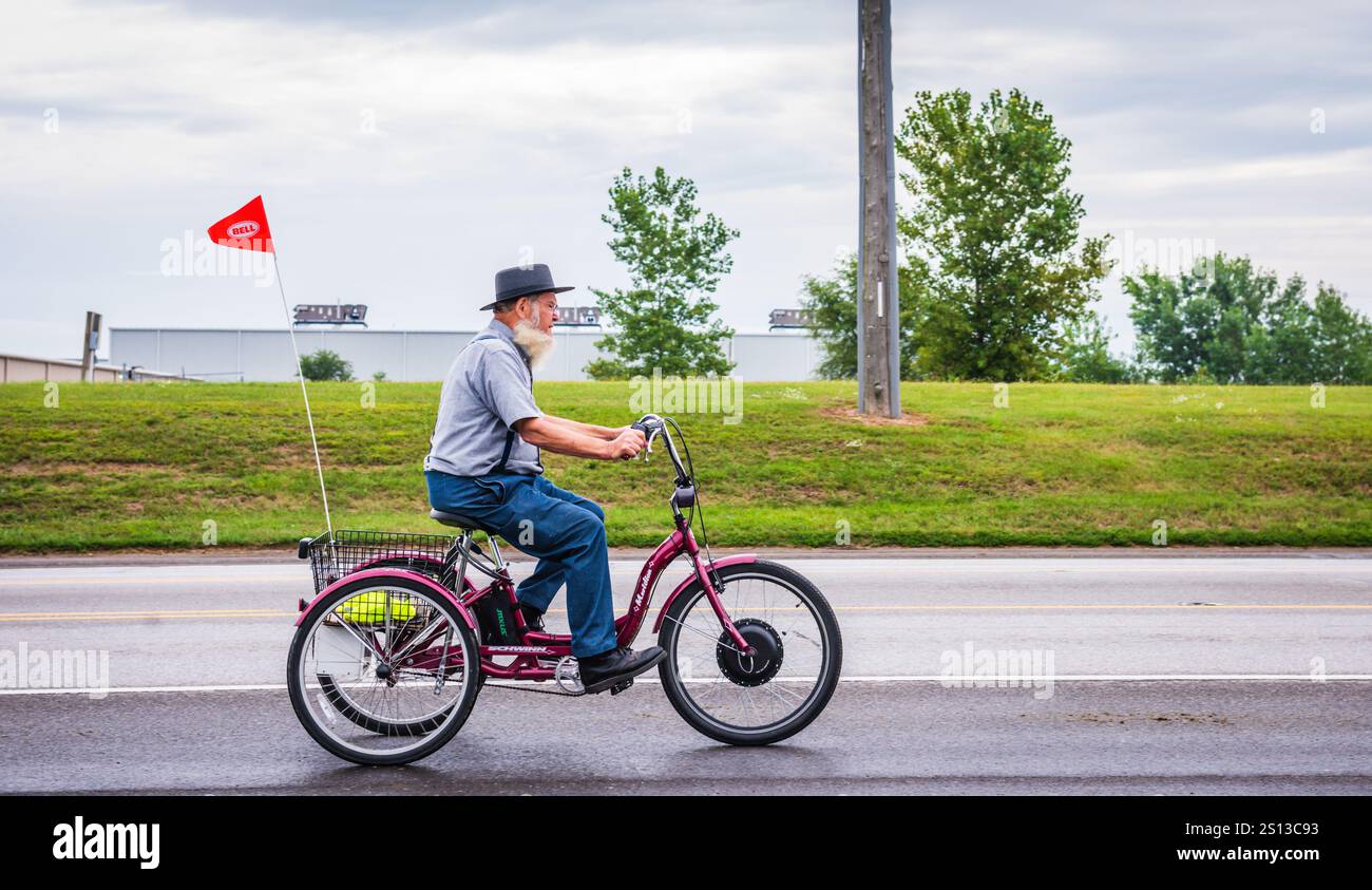 Shipshewana, INI USA - August 28, 2017: Bearded Amish man rides trike on road in Shipshewana, Indiana. Stock Photo