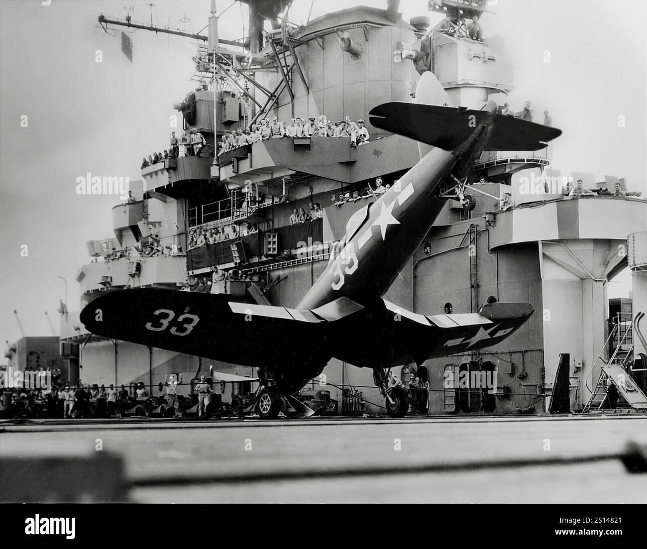 A Vought F4U Corsair on its nose on the carrier USS Shangri-La. An American fighter aircraft primarily of World War II and the Korean War, it was designed and principally operated as a carrier-based aircraft with the U.S. Navy and Marines. One of the most capable carrier-based fighter-bombers of the war, some Japanese pilots regarded it as the most formidable American fighter. The Corsair served almost exclusively as a fighter-bomber throughout the Korean War and during the French colonial wars in Indochina and Algeria. Stock Photo