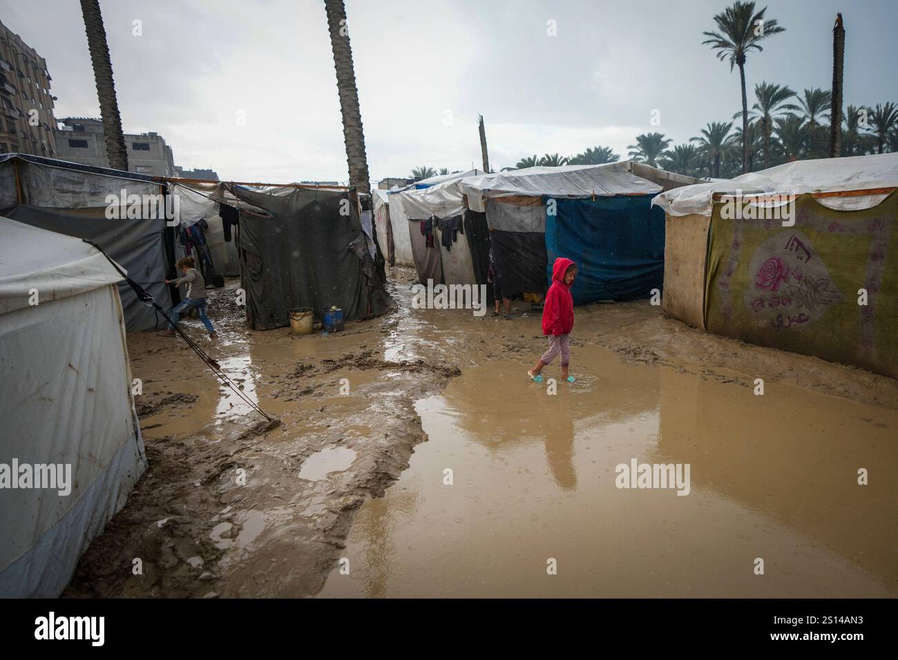 A young girl walks through a flooded street following overnight ...
