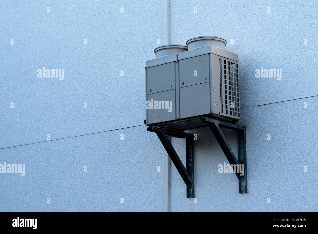 A wall-mounted air conditioning unit is neatly installed on a white ...